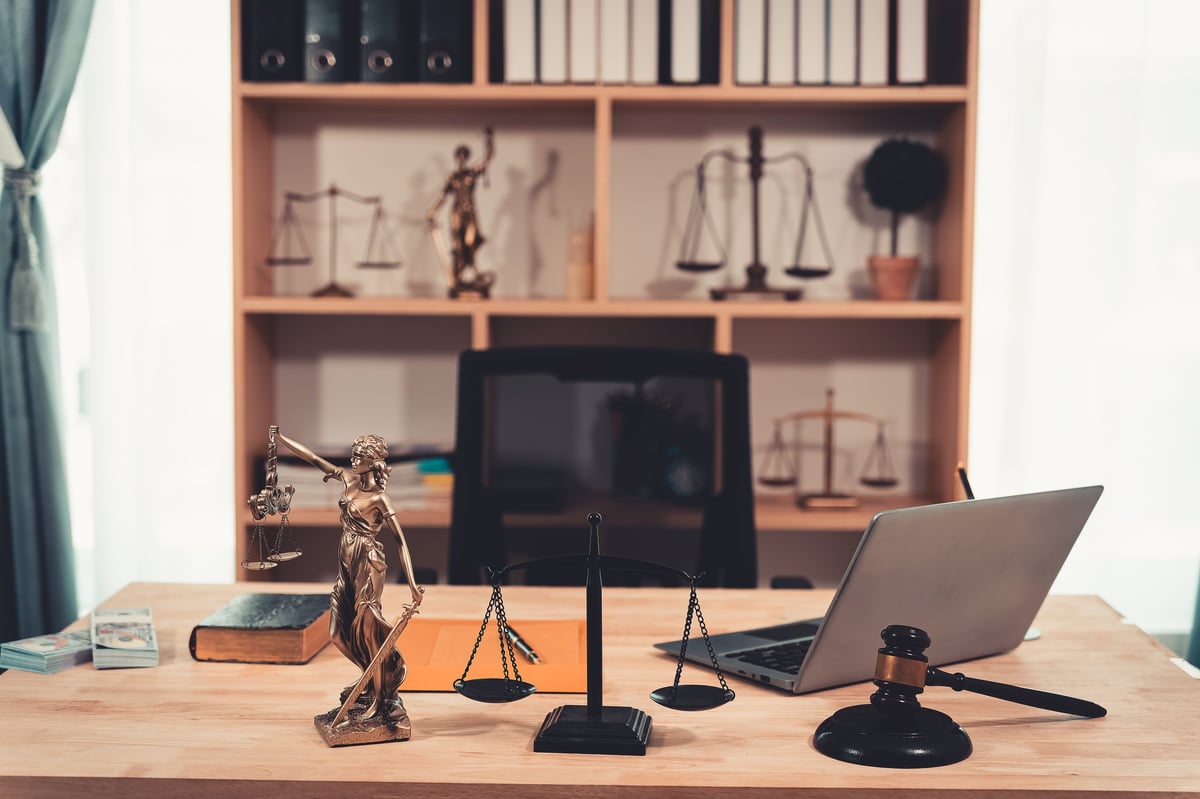 Balanzas de justicia en escritorio legal con documentos digitales